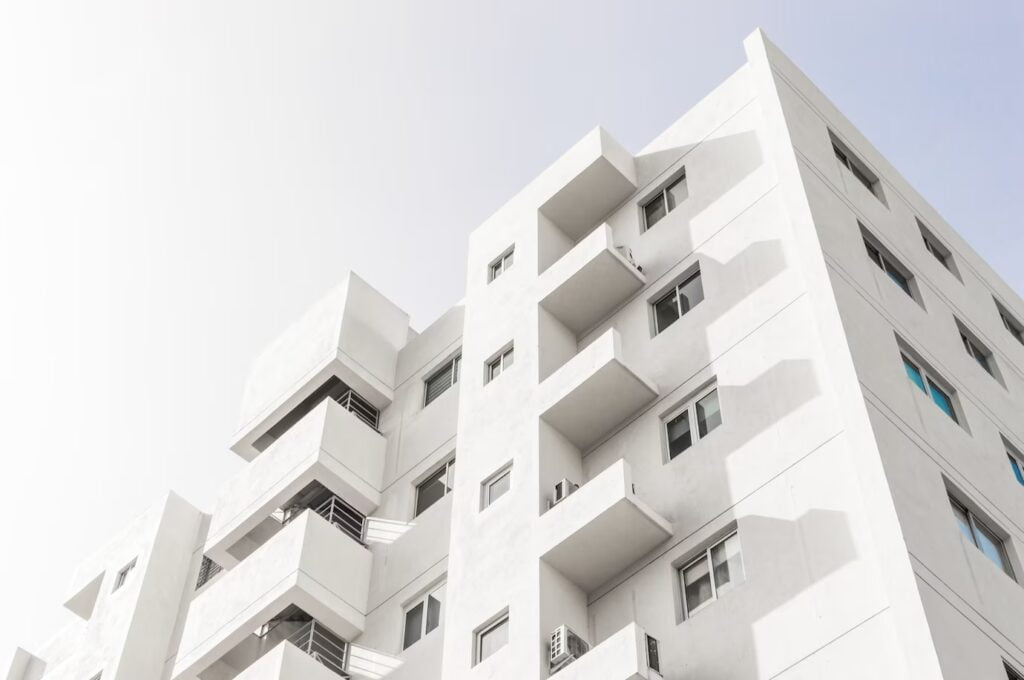 foto de baixo angulo da fachada de um edificio moderno branco sob um ceu azul claro 181624 48219