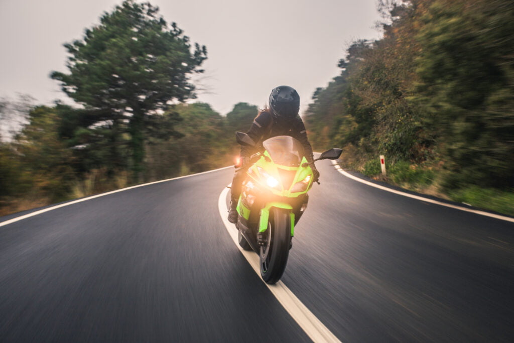 conduzindo a motocicleta de cor verde neon na estrada vista frontal